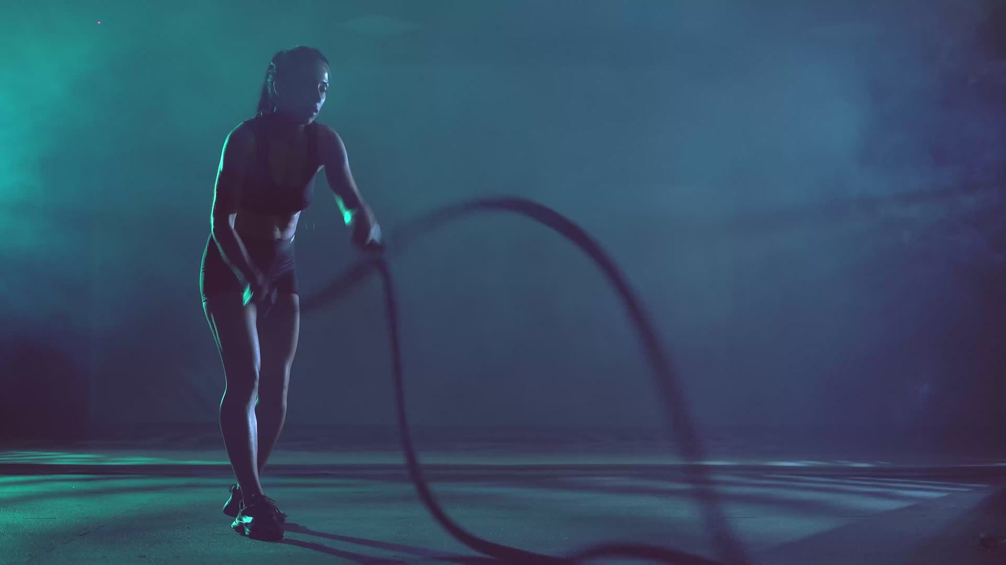 Powerful woman training with battle ropes fuelled by clean protein